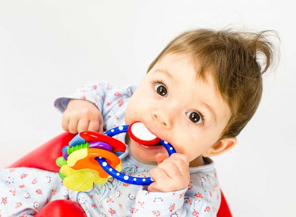 teething baby girl girl chewing on a toy text choosing a sensory chew toy autism