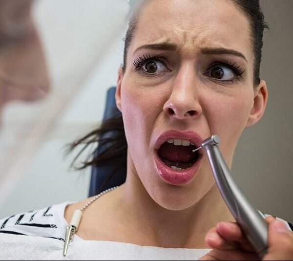 Young woman scared during a dental check-up at clinic Young woman scared during a dental check-up at clinic