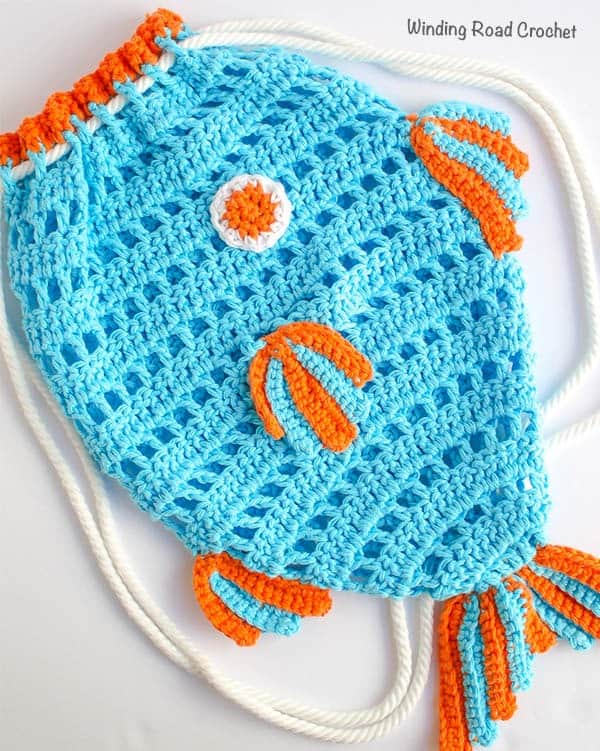 The Fish Beach Backpack is the kids way to help drag all the beach toys to the pool with their own crochet beach bag. This free crochet pattern has photos to walk your through the whole project. #crochet #beachbag #freepattern
