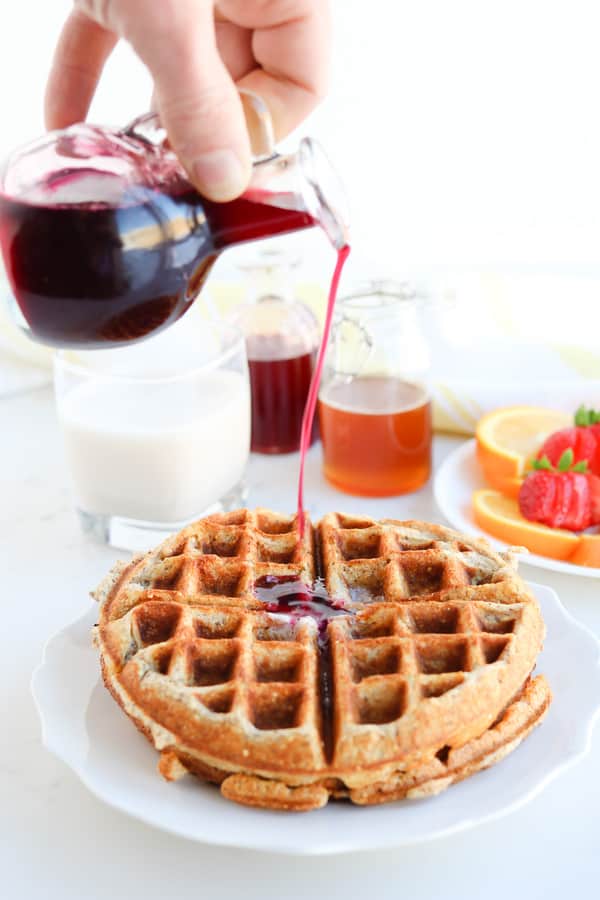 Pressure Cooker Infused Honey Syrup being poured onto a waffle