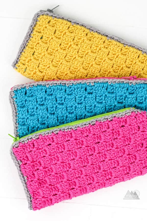 Corner to Corner crochet zipper pouch is a perfect first crochet pattern for beginners that just learned the corner to corner crochet stitch. Check out the accompanying post that has video and photo tutorials for how to corner to corner crochet. This crochet bag can hold pens, hooks, and other supplies. There is a photo tutorial for how to add a no sew liner. #c2ccrochet #crochetbag