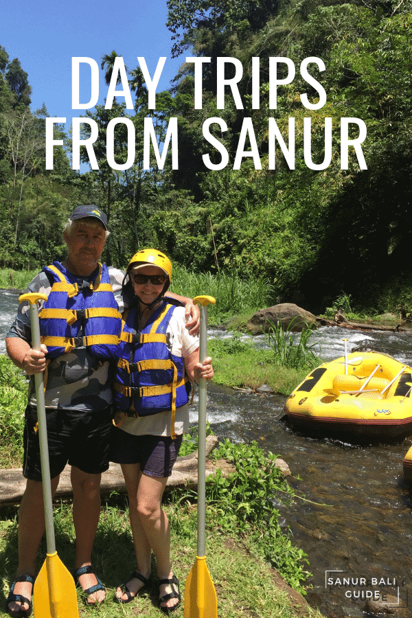 Day Trips From Sanur A couple standing with Oars with a raft nearby from White Water Rafting in Bali