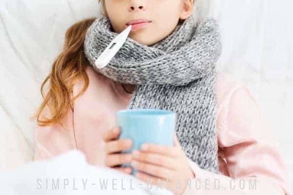 Sick child holding a cup of homemade pedialyte