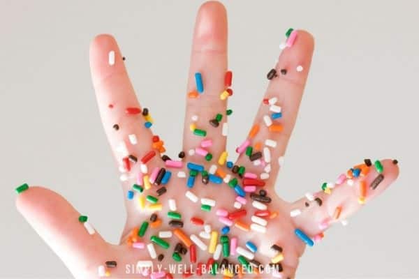 Child's hand covered in sprinkles
