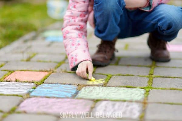 Child drawing with sidewalk chalk