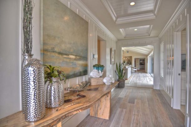 a beach-style hall with shiny white trim and greyish wood floor