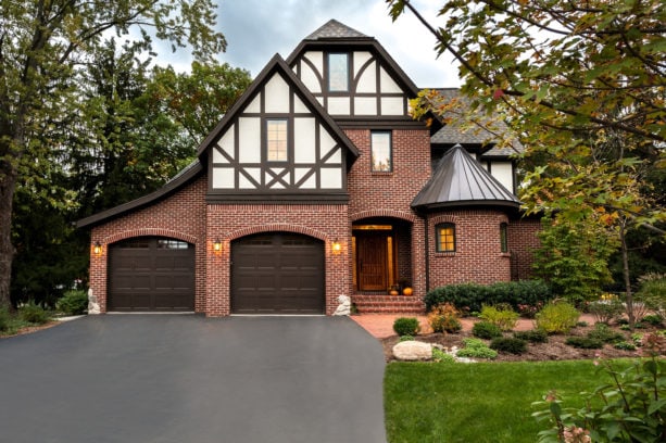 a home exterior with the combination of red brick, brown paint, and white color