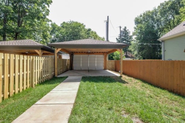 simple carport idea in front of a crisply white garage