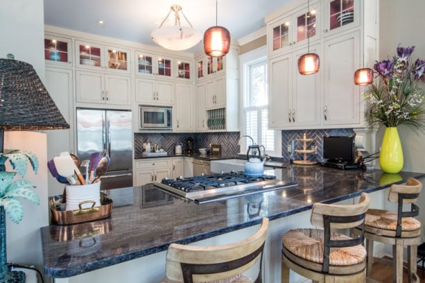 elegant u-shaped kitchen with a peninsula and three bar stools