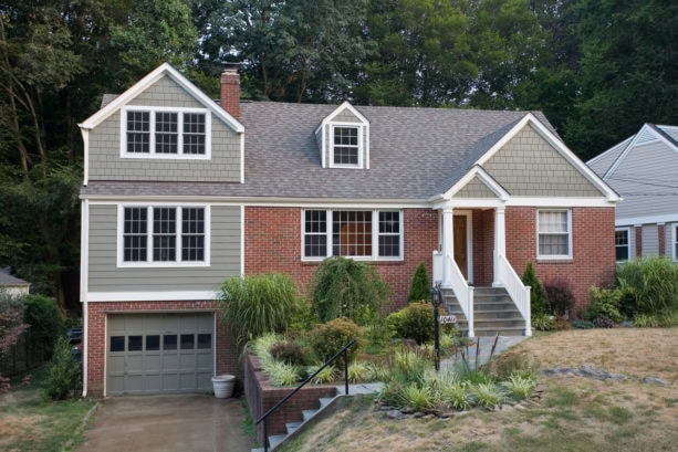 the combination of red brick and greige siding for building a traditional feel in home exterior
