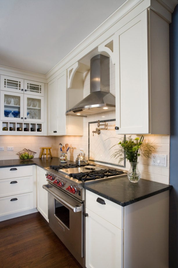 ceramic subway tile and soapstone liner backsplash behind stove with a pot filler