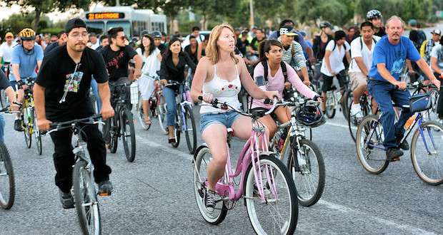 Woman on a pink cruiser bike in the middle of a bike rally