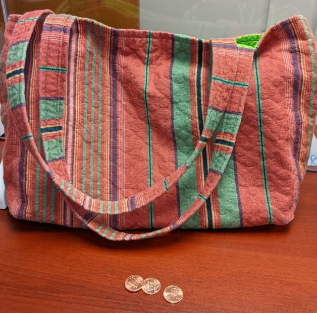 Red and orange homemade bag with handles.