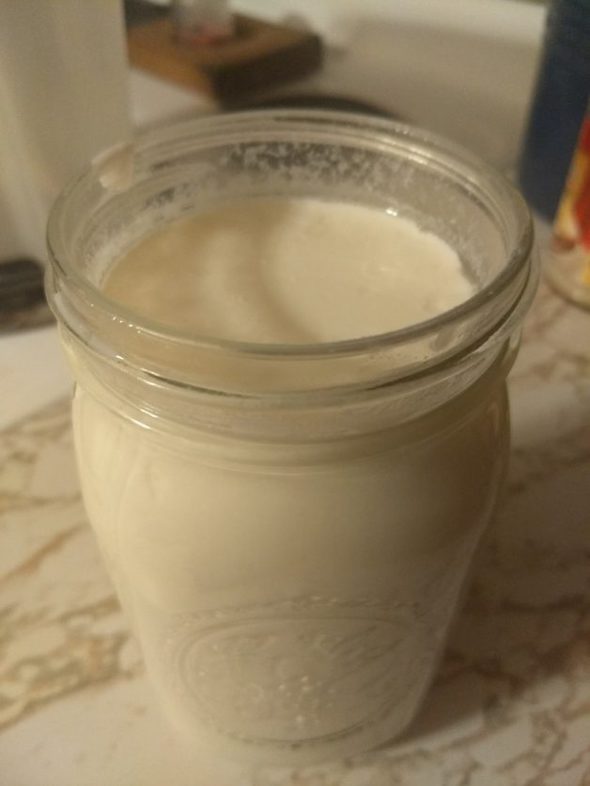 Glass Mason jar of homemade yogurt.