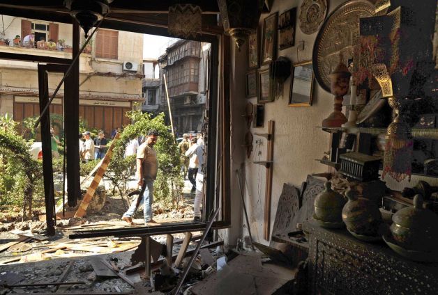 This photo released by the Syrian official news agency SANA, shows a Syrian security agent looking at a damaged antique shop after a blast struck in the vicinity of the Greek Orthodox Virgin Mary Church in the predominantly Christian neighborhood of Bab Sharqi in central Damascus, Syria, Thursday, June 27, 2013. A suicide attacker blew himself up near one of the main churches in the Syrian capital Thursday, killing several people, state-run TV said. Photo: SANA