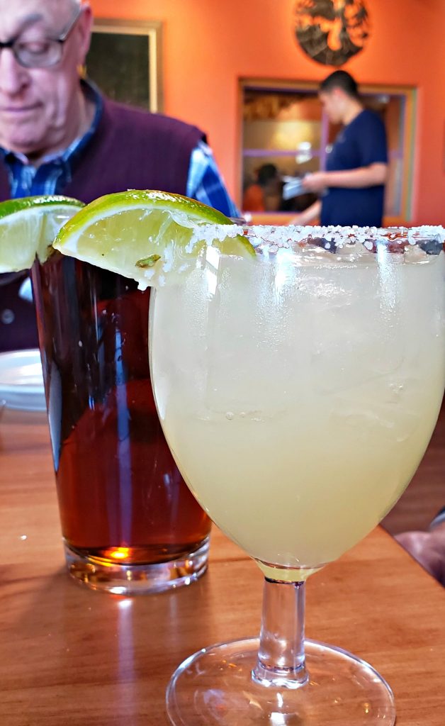 One of the best margarita santa fe sits next to a dark draft beer at La Choza restaurant