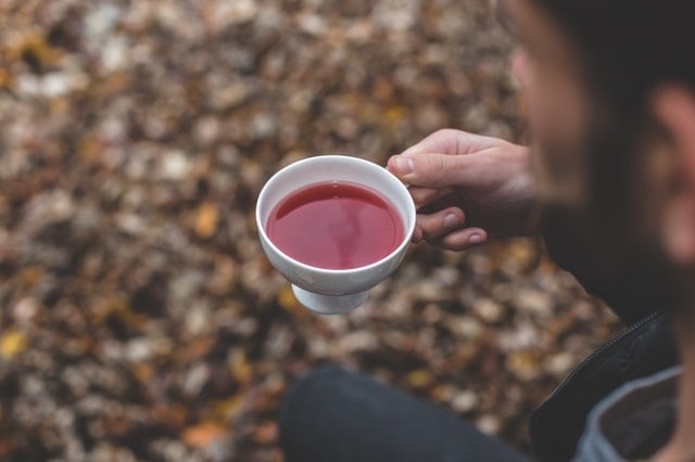 Person holding cup of black tea Person holding cup of black tea