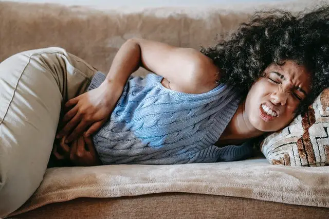 Woman in pain on couch Woman in pain on couch