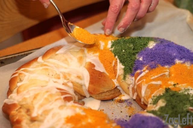 Topping King Cake with yellow, green, and purple sanding sugar