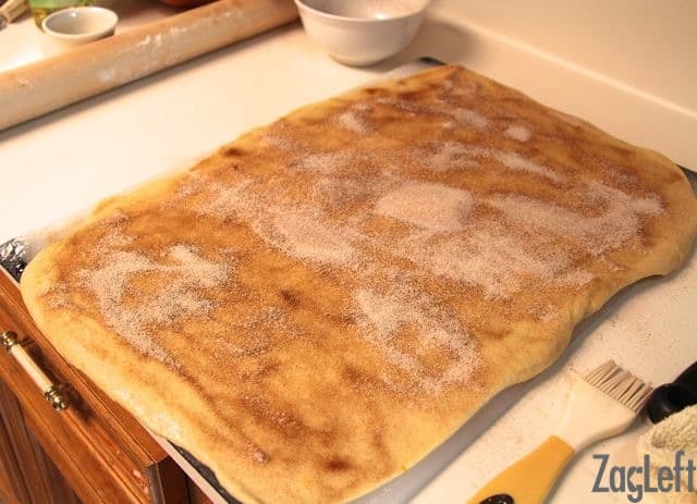 Cinnamon sugar sprinkled over the rolled out dough