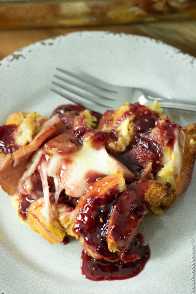 monte cristo casserole with raspberry sauce on a gray plate
