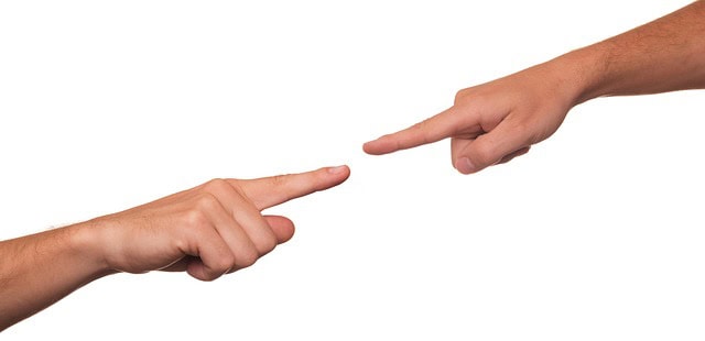 Image of two arms and hands extended with pointer finger of each pointing at each other, showing how a southern WV abuse and neglect defense attorney can help defend you when accusations are made.