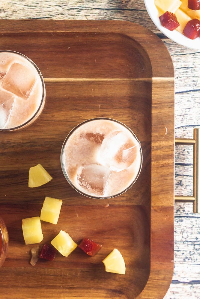 overhead view of starbucks iced guava passionfruit drink on a platter with pineapple