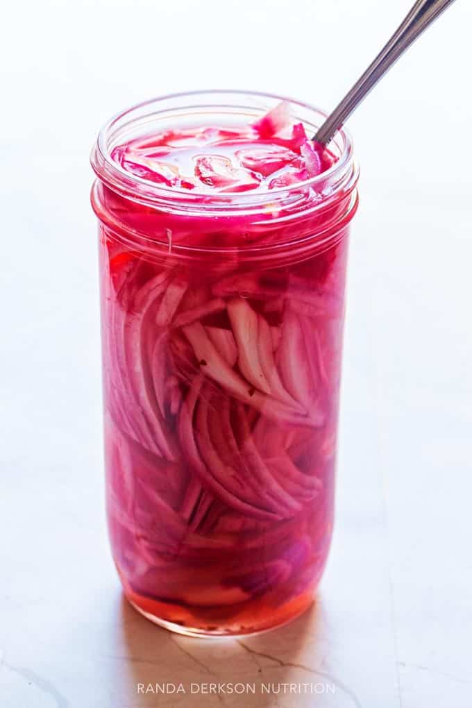thinly sliced red onion in a brine in a mason jar
