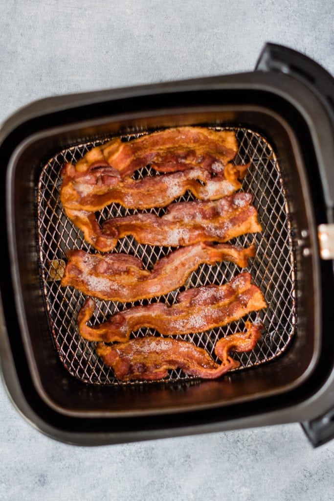 cooked bacon inside the air fryer basket