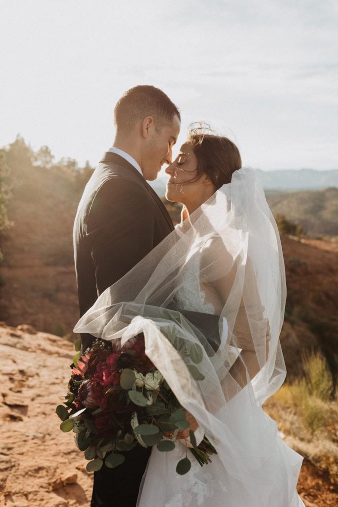 Bride and groom embrace in the desert during their adventurous Tlaquepaque wedding in Sedona, Arizona photographed by Alexa Ann Photography.