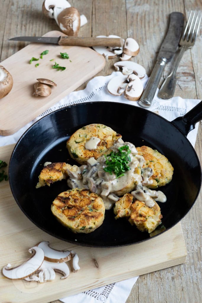 Rezept Serviettenknödel mit Pilzsoße 3 Serviettenknödel mit Pilzsoße und frischen Kräutern. Serviert in einer Pfanne.