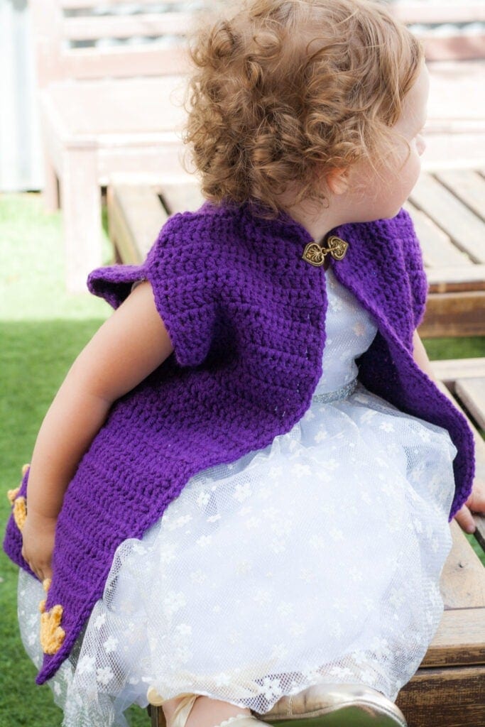 Don't let your girl be a frozen princess on Halloween. Keep her warm with this Crochet Cape Coat. Free crochet pattern by Winding Road Crochet. #crochetprincess #crochetcape #crochetcostume #frozen
