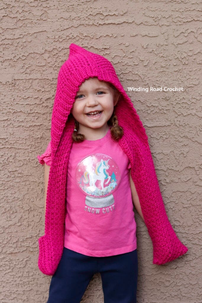 The Hinterlands Hooded Crochet Scarf in a free easy crochet pattern for a scarf with a hood and pockets. Sizes include toddler through adult.