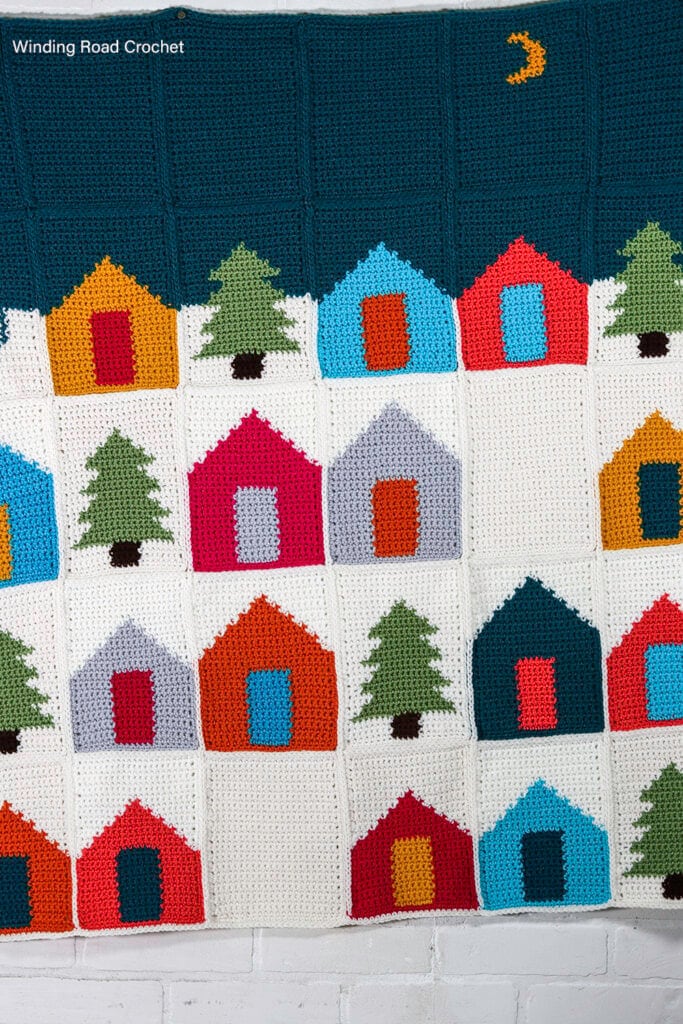 Use up your scrap yarn while crocheting this Winter Village Crochet Afghan. The free crochet pattern provides instructions for many sizes.