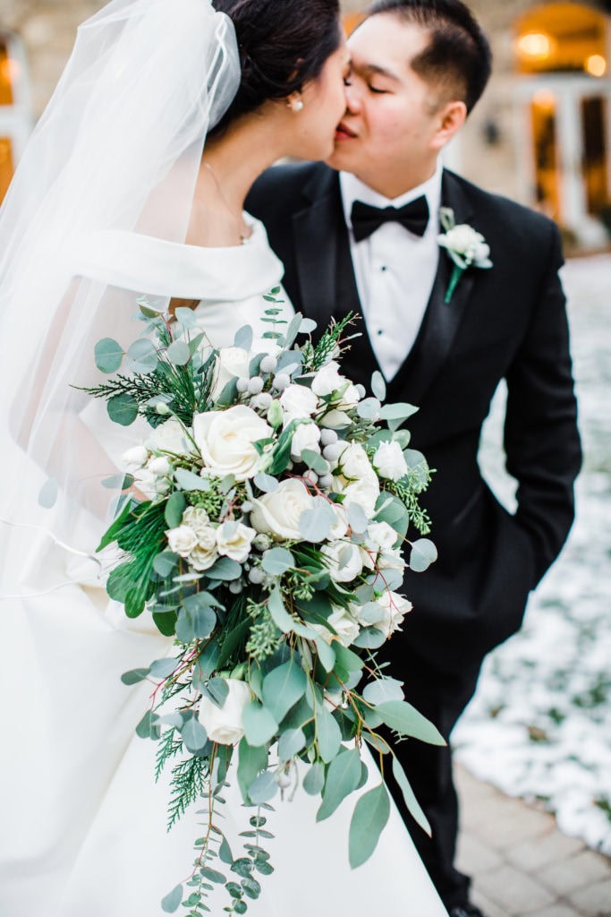 bride and groom kissing outside of the venue closeup