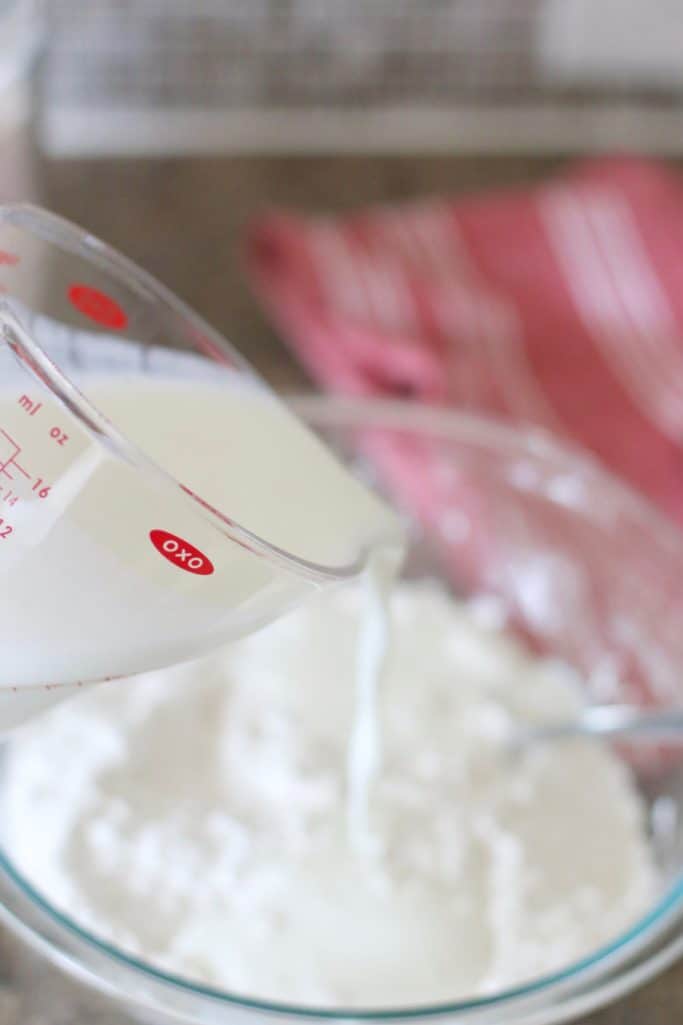 whole fat buttermilk being poured into flour mixture
