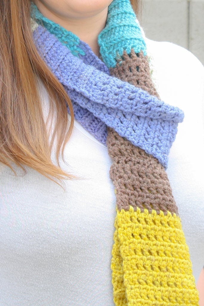 Want a quick and easy friday night project? Work up this free crochet pattern for an infinity scarf with lots of unique texture and appeal. This is a one skein project that you can have ready for the weekend. My example uses Caron Cakes yarn and is a bright and colorful addition to my wardrobe.