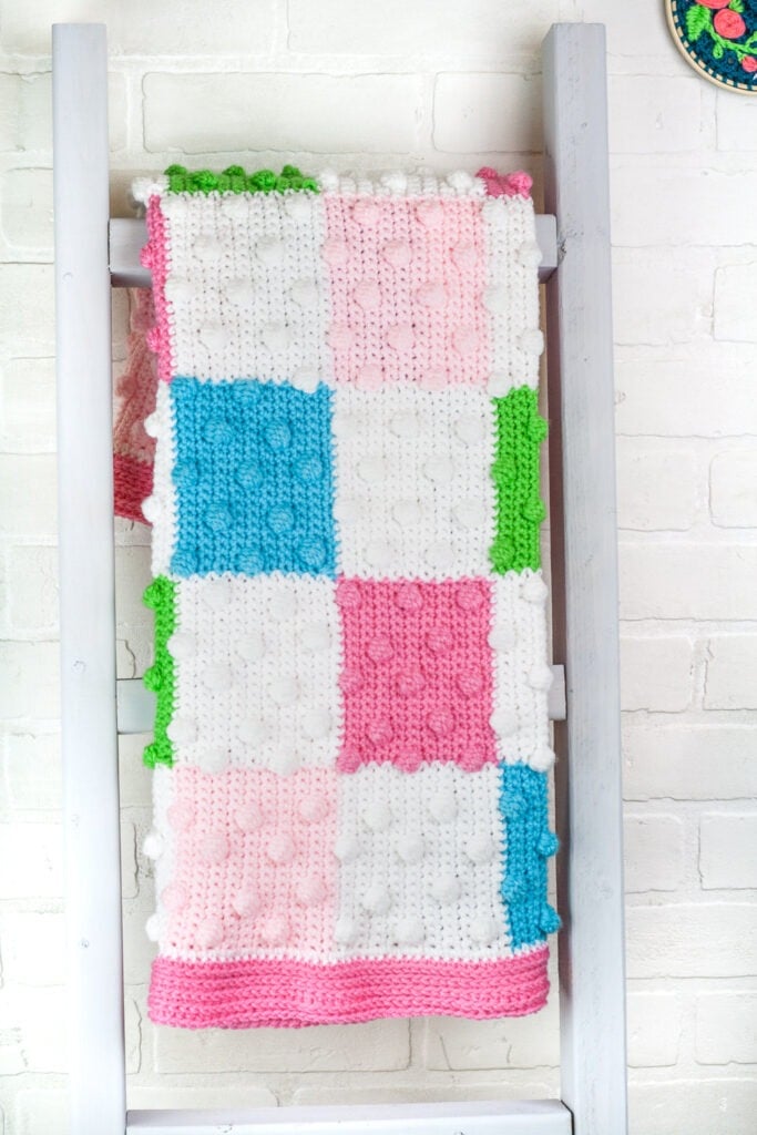 Free crochet pattern for a beautiful and colorful bobble baby blanket. There are 4 added video tutorials to help walk you through how to make this blanket.