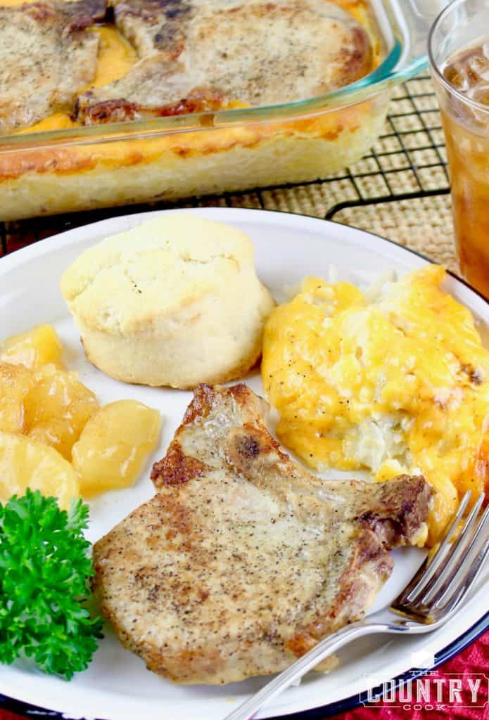 final plating of pork chops, hash brown casserole, biscuits and fried apples