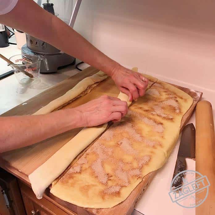 Rolling the three strips of dough topped with cinnamon sugar