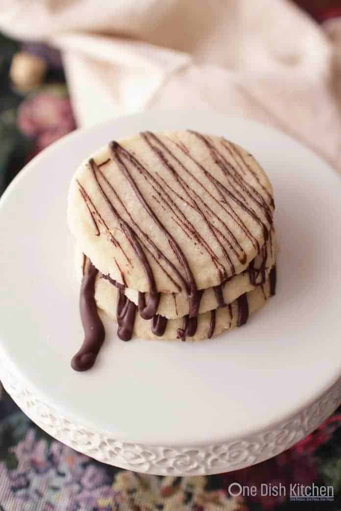 A stack of three shortbread cookies drizzled with melted chocolate