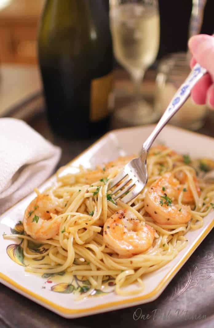 shrimp scampi on a plate with a glass of champagne | one dish kitchen