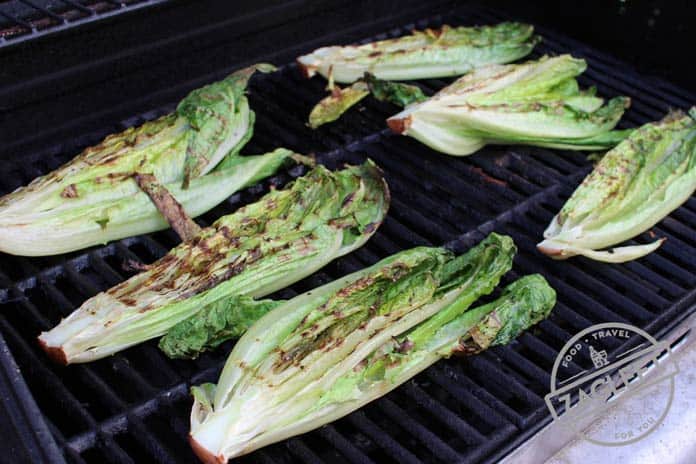 Romaine lettuce on the grill with char marks after it has been turned - zagleft.com