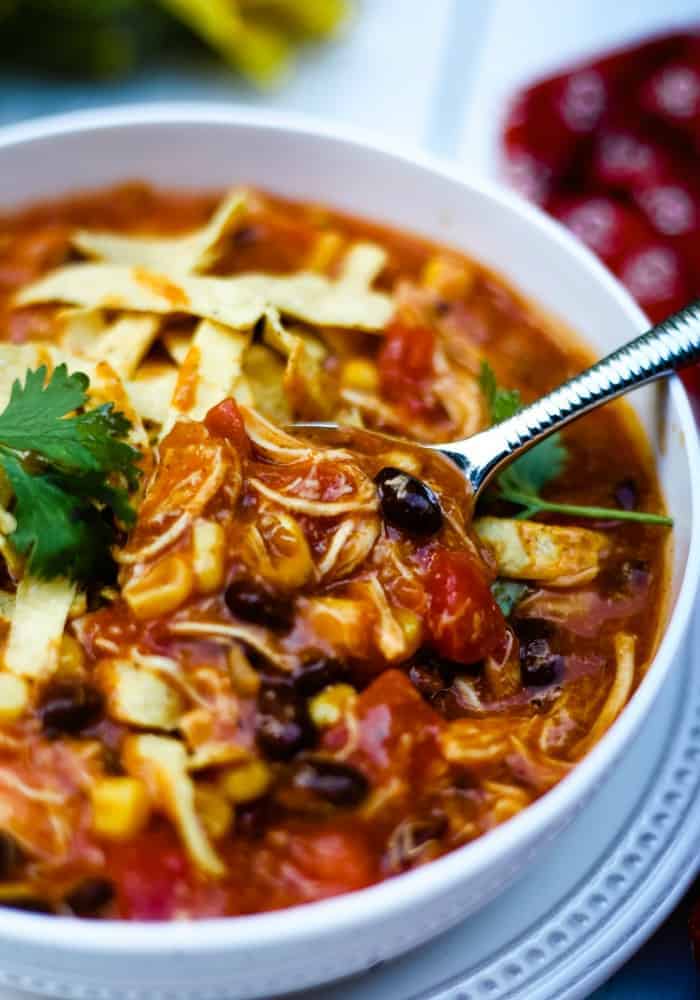 A close up of A bowl of food on a plate, with Chicken Tortilla Soup