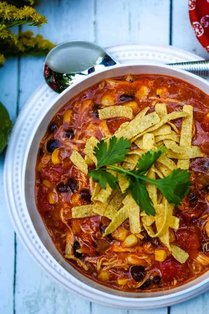 A bowl of food on a plate, with Chicken Tortilla Soup
