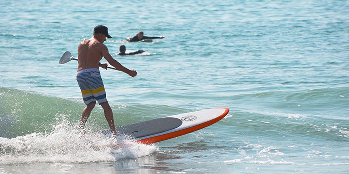 SUP surfing is becoming more popular every year. Epoxy paddle board being used for surfing