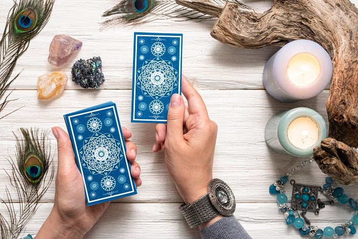 tarot card numbers person reading tarot with crystals