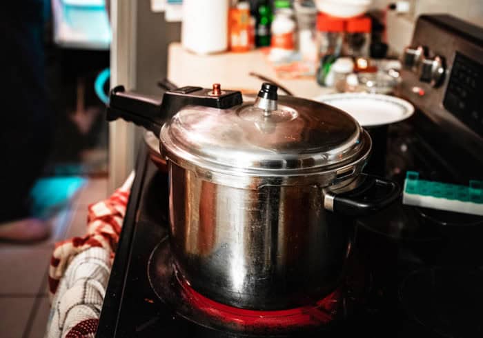 Pressure cookers have come a long way from stovetop pots to electric Instant Pots that can be used in RVs. old pressure cooker on a stove