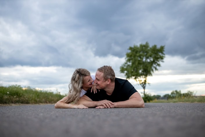 Paarfoto auf der StraĂe liegend PĂ€rchenfoto auf der StraĂe liegend gegen einen Wolkenhimmel fotografiert Canon EOSR & EF 35mm f/1.4l ii usm