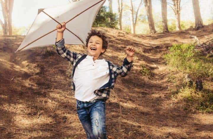 Best Outside Toys for Boys age 6-10. Boy playing outside with kite.